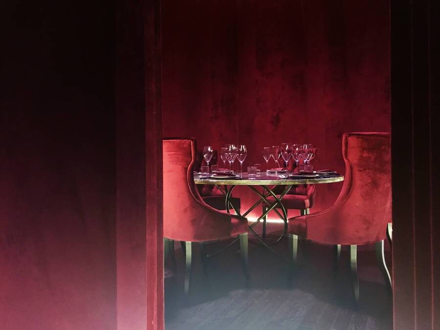 Red private room and velvet wall surfaces, showing the organic wall form converging toward the light.