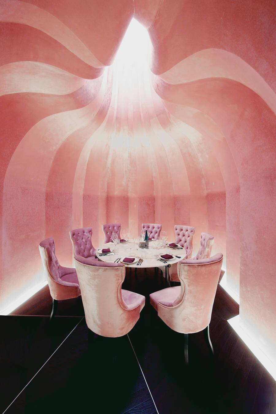 Pink private room with overhead light, where curved enclosure creates a soft dreamlike atmosphere.