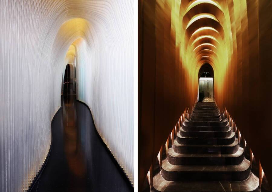 Wormhole-like stair connecting the first and second floors, with curved walls and linear lighting guiding vertical circulation.