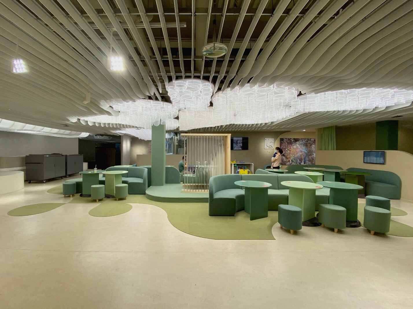 Semi-open classrooms and shared learning space with low partitions, flexible furniture, and nature-inspired interior lighting.
