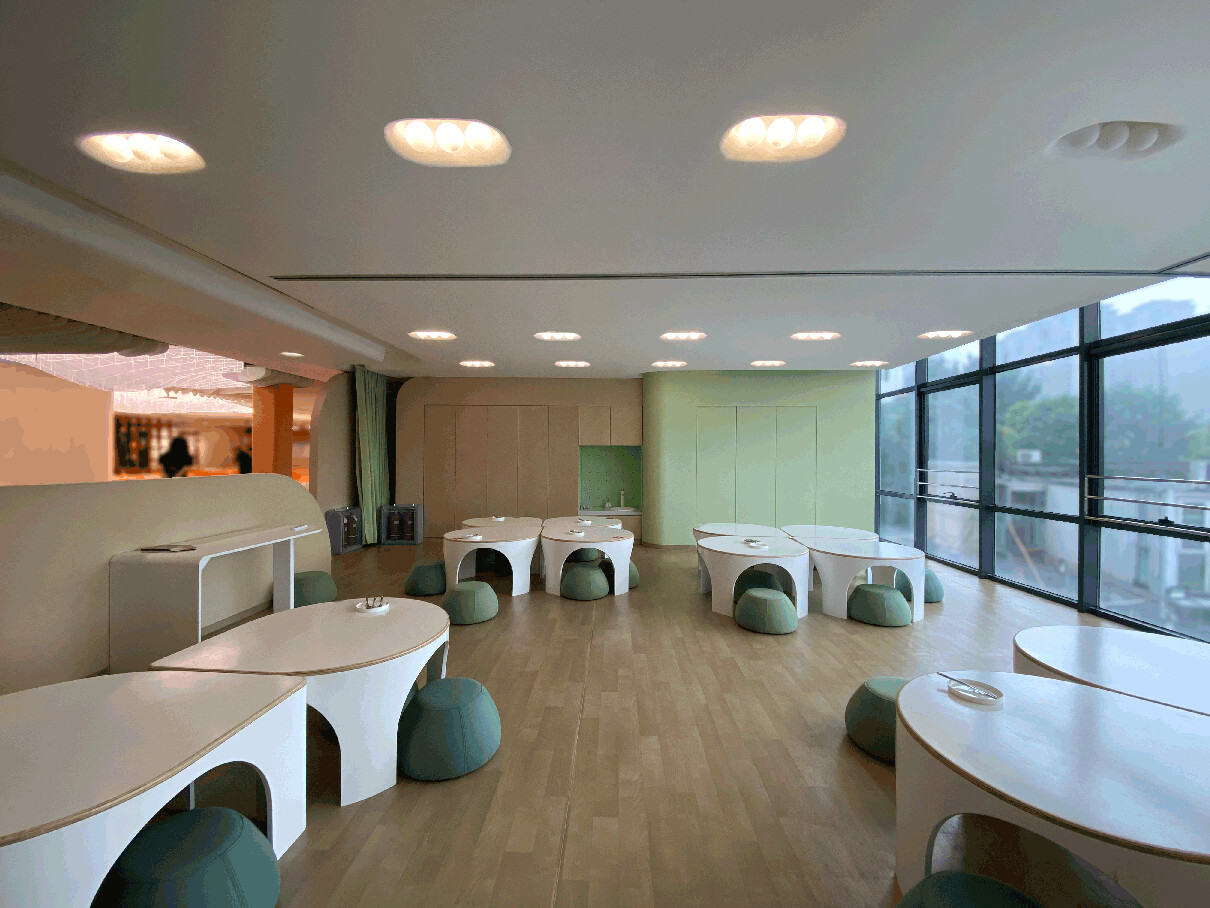 Multifunctional classroom with reconfigurable furniture, low walls, and a learning environment scaled for children.