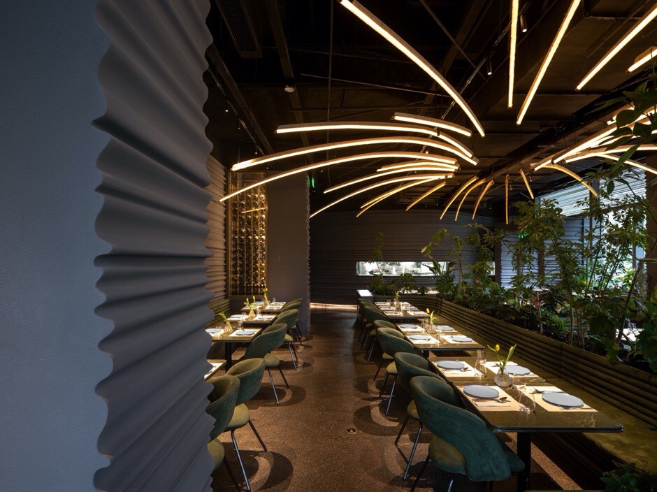 Existing column and wine display rack enclosing a semi-private booth and strengthening the sense of spatial intimacy.