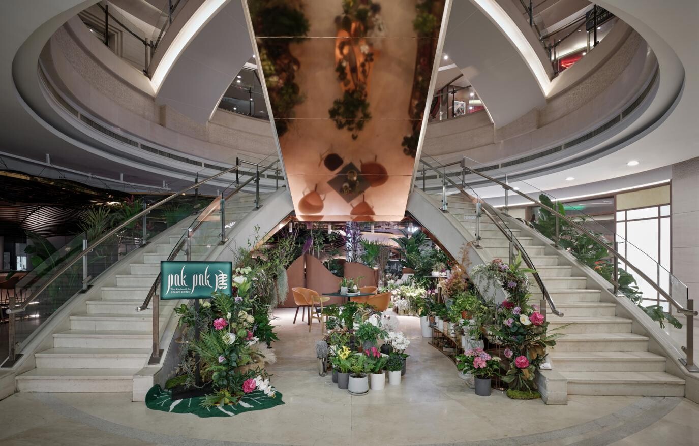 Atrium transformed into an island garden, with planters like boats moored by an island creating a green transition between the restaurant and public mall space.
