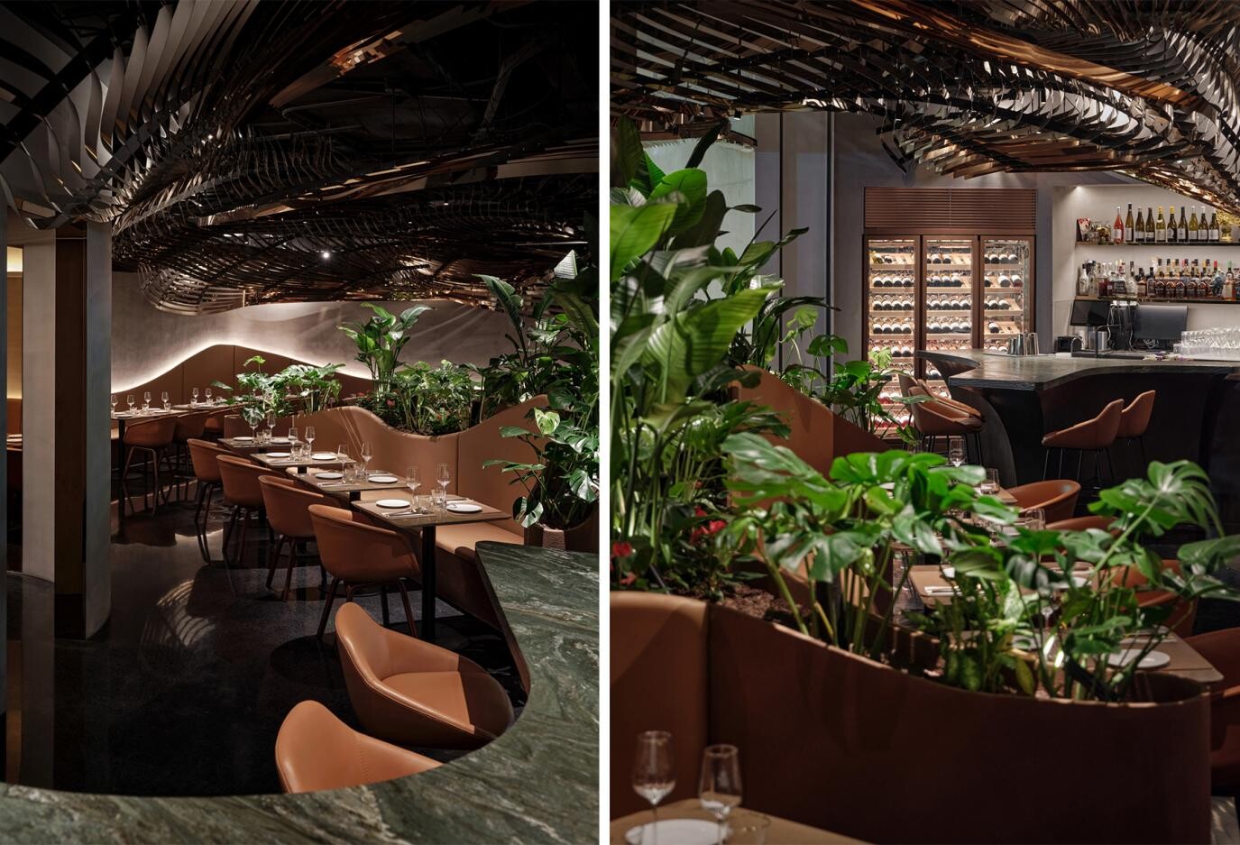 Dining area continuing the atrium’s planting language, where plants, curved partitions, and low lighting create an immersive tropical-rainforest experience.