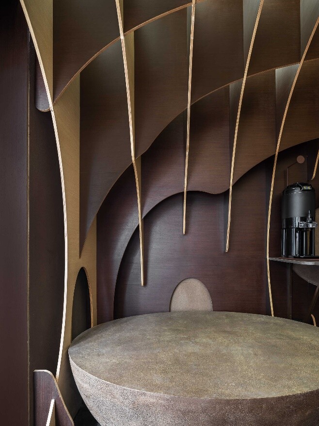 Coffee-bean curve transformed into circular seats and tables in the waiting area, extending the store’s spatial language.
